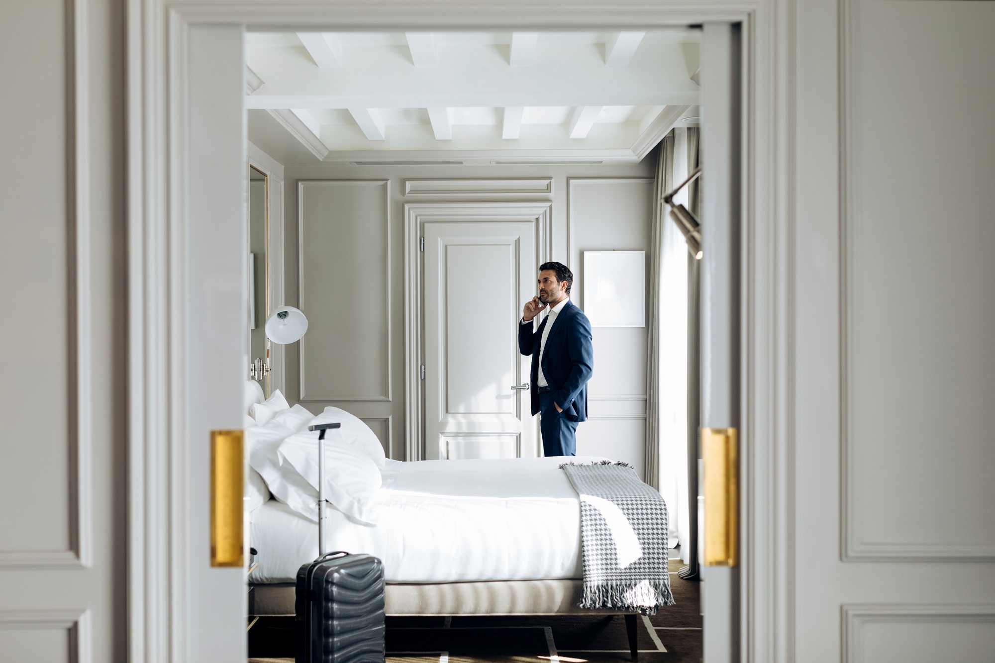 Businessman on a phone call in a luxury hotel room.